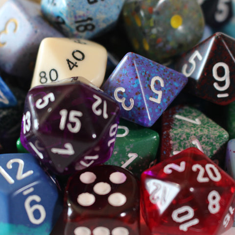 assortment of multi-sided dice of varying color and design